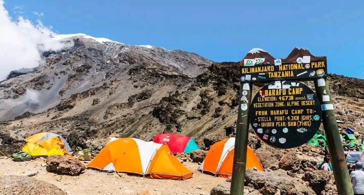 Barafu camp signboard above orange tents on Mount Kilimanjaro