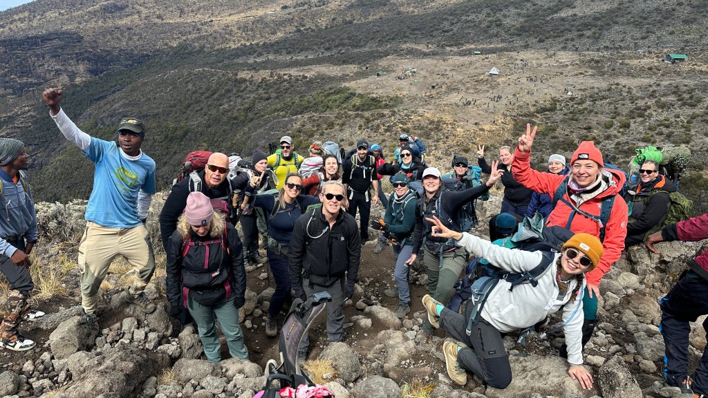 Large trekking group posing above a moorland camp on Mount Kilimanjaro