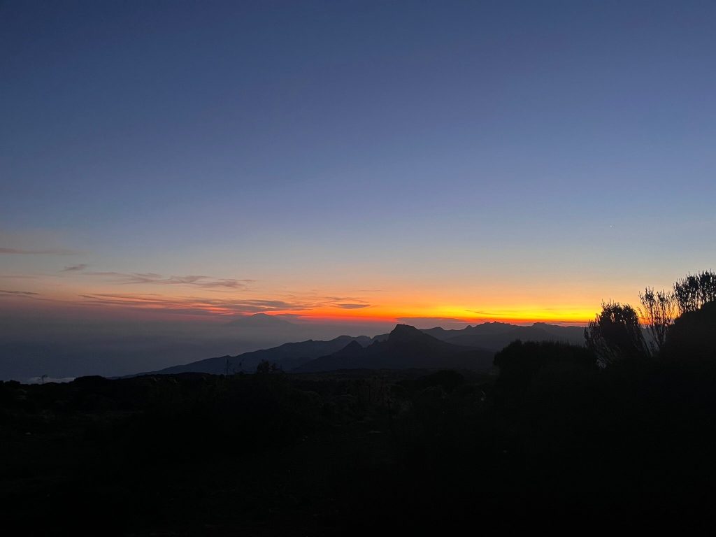 Orange sunset over a jagged ridge seen from the Kilimanjaro moorland