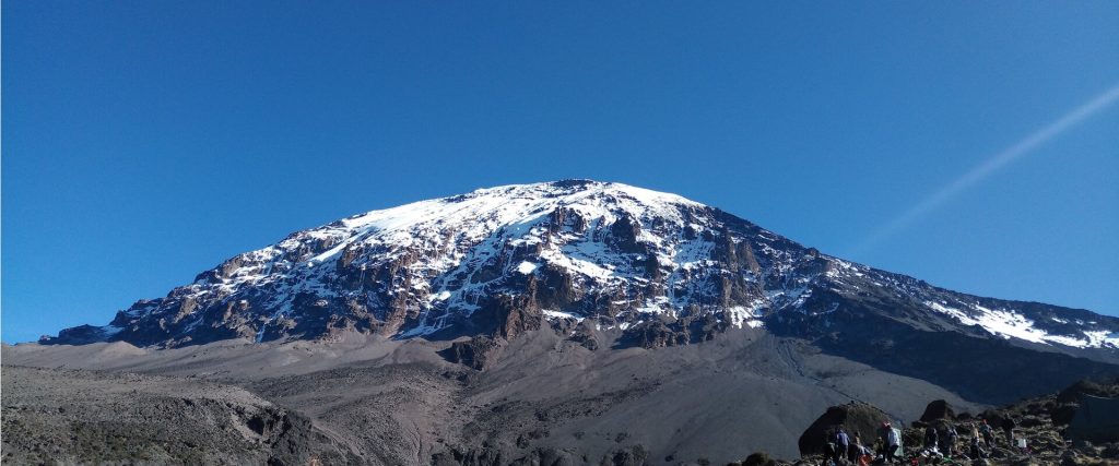 Snowcapped kibo dome above alpine desert scree on Mount Kilimanjaro