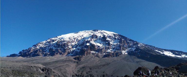 Snowcapped kibo dome above alpine desert scree on Mount Kilimanjaro