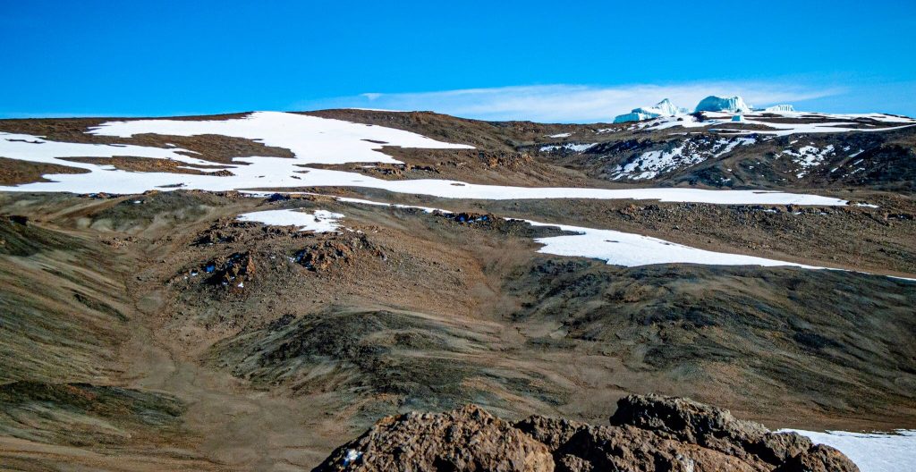 Snowfields and distant glacier ice cliffs high on Mount Kilimanjaro